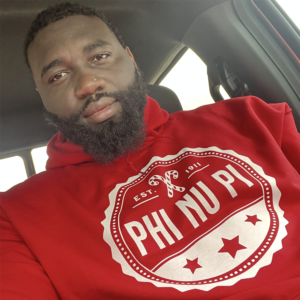 Young Nupe wearing a Phi Nu Pi Seal hoodie.